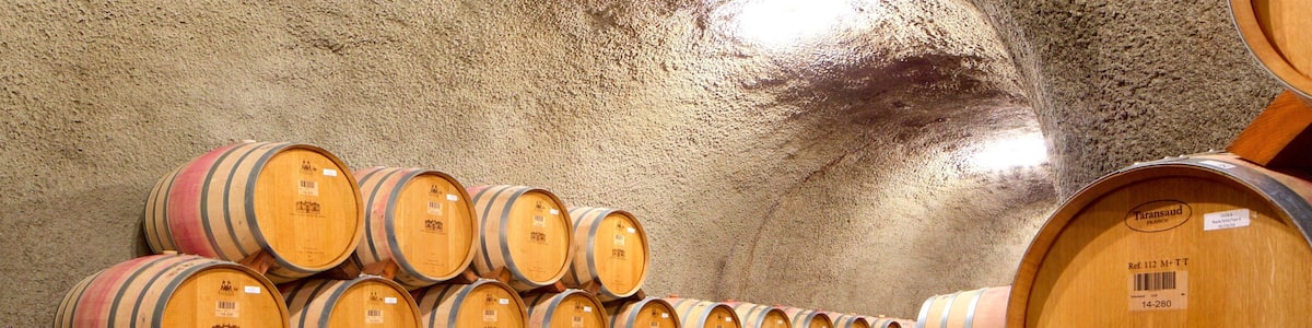 Wooden wine barrels stacked in a warehouse.