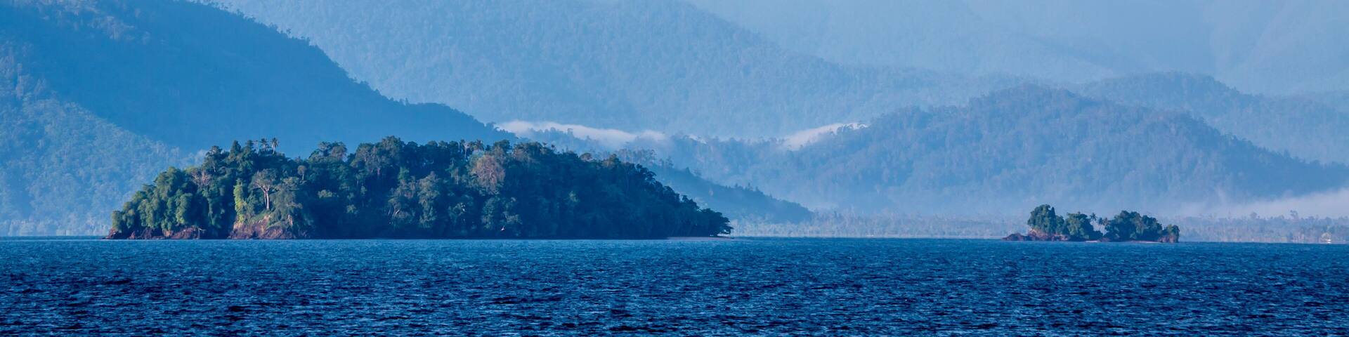 Vista of rainforest covered coast, hills and islands from the Solomon Sea off the shore of Morobe Province, Papua New Guinea; Morobe Province, Papua New Guinea