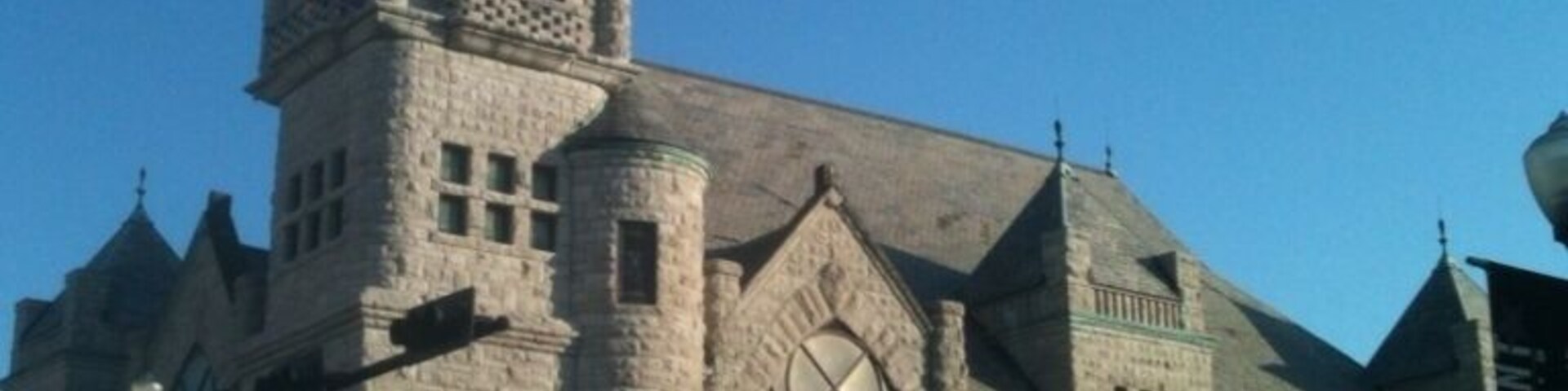 The most eye-catching building in downtown Beaumont is the Tyrrell Library. Constructed in 1903 as the First Baptist Church of Beaumont, it replaced a red brick church that had previously occupied the site. 
The rough-quarried limestone exterior instantly reminds the first-time viewer of a medieval castle (with stained-glass windows). The building is an example of Richardsonian design. Professor Jay C. Henry in his book Texas Architecure 1895 - 1945 states that it might pass for Richardsonian Romanesque "were two great Gothic windows not used to light the sanctuary." We were about to say the same thing.