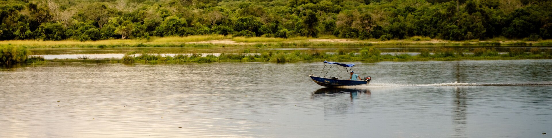 A small boat on the Nile river during sunset in Murchison Falls national park in Uganda.Too bad this place, lake Albert, is endangered by oil drilling companies