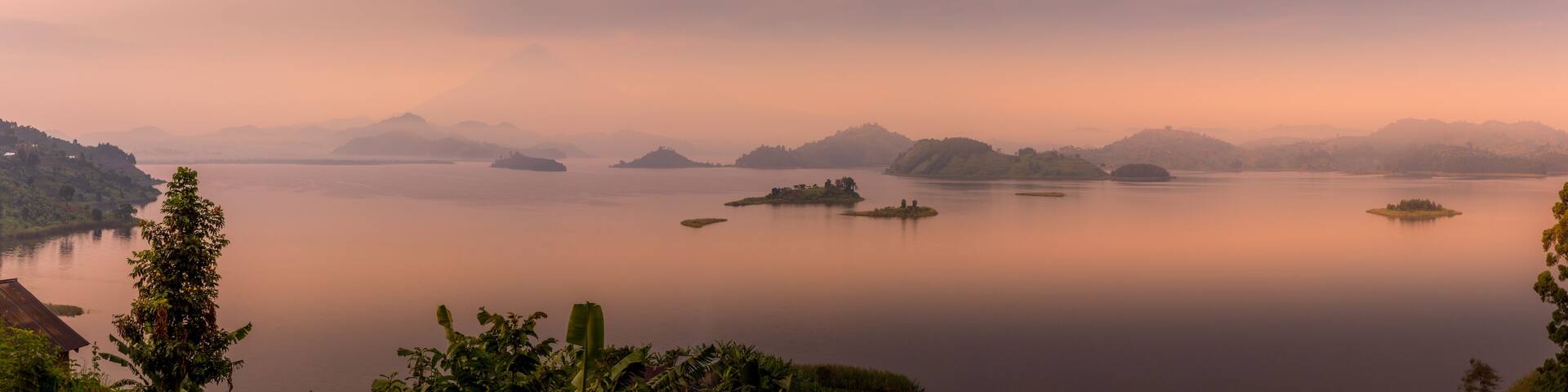 Panorama of Lake Mutanda at morning with view on the volcanoes mount Muhavuru and mount Gahinga in East Africa, along the border of Rwanda and Uganda.