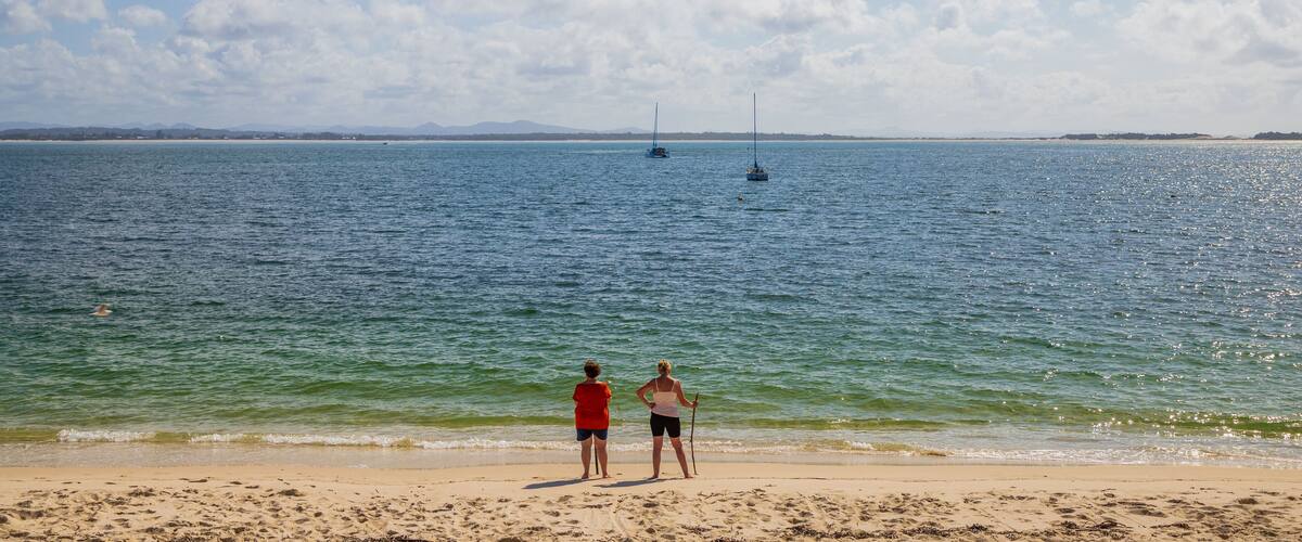 Shoal Bay Beach which includes a beach and general coastal views as well as a couple
