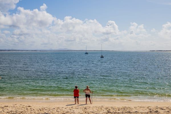 Shoal Bay Beach which includes a beach and general coastal views as well as a couple