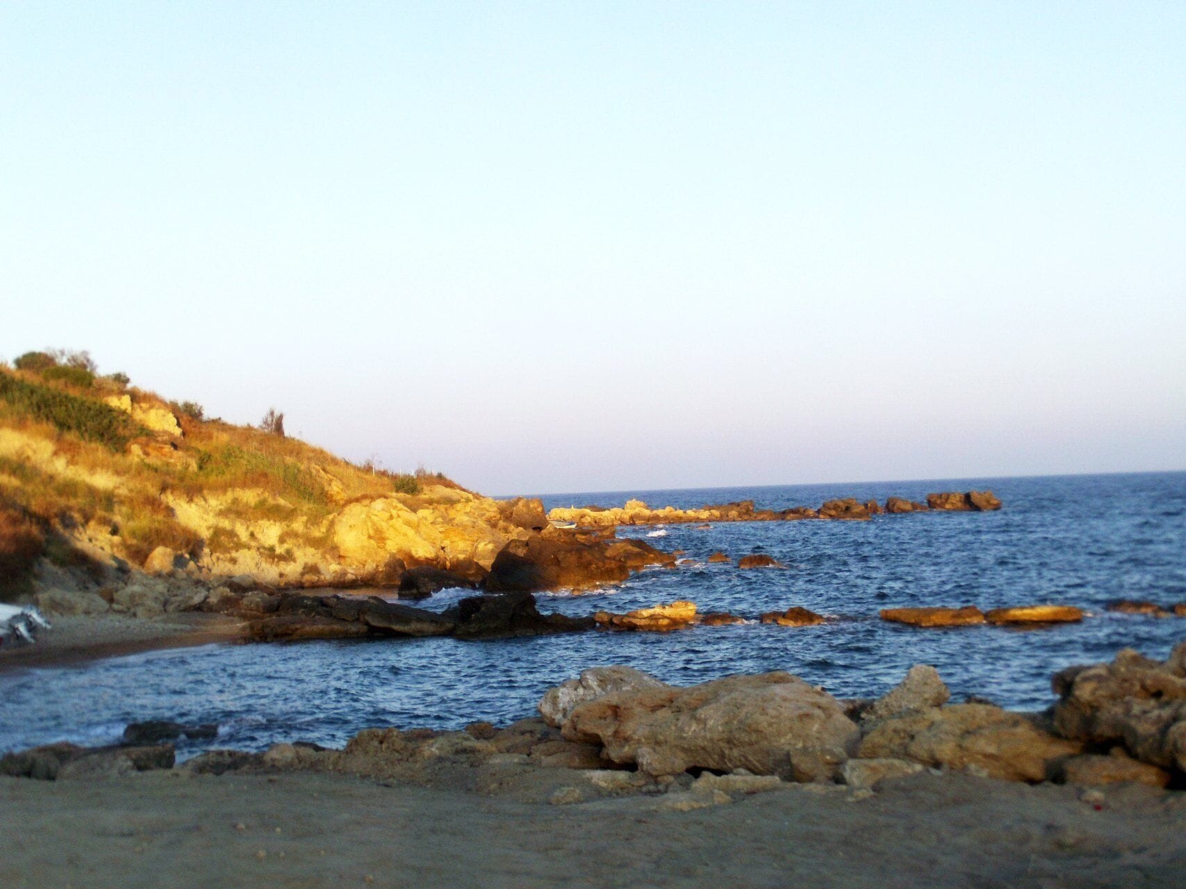 A rocky coastline with waves crashing against the shore.