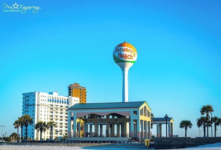 A beachside building with a large water tower labeled 'Pensacola Beach'.