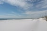 En snötäckt strand med havet i bakgrunden.