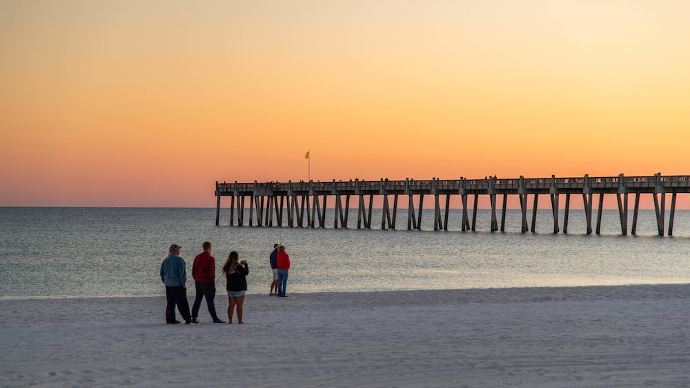 Pensacola Beach which includes a beach, a sunset and general coastal views