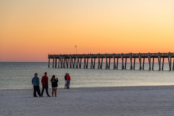 Pensacola Beach which includes a beach, a sunset and general coastal views