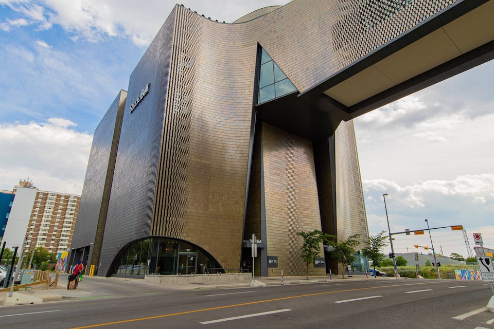 Um edifício moderno com fachada ondulada e uma grande saliência.