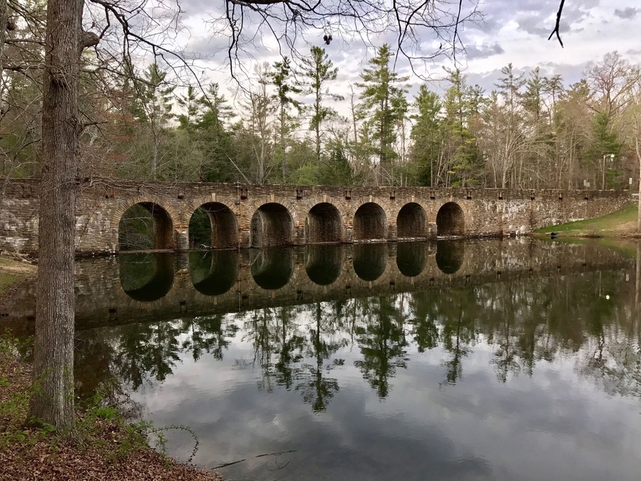 After eating at the park buffet, head over beyond this beautiful bridge to see a quaint little cabin and picturesque waterfalls under the bridge.