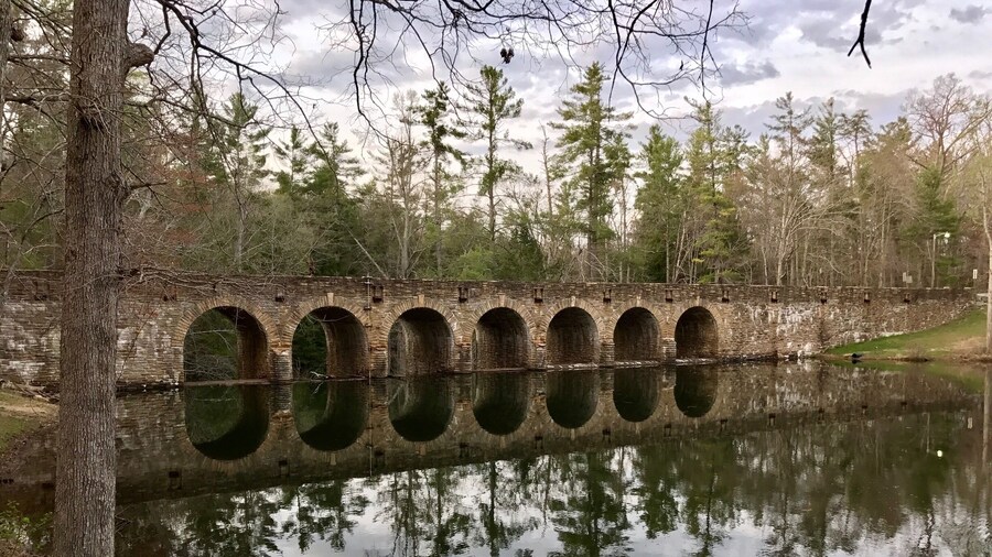 After eating at the park buffet, head over beyond this beautiful bridge to see a quaint little cabin and picturesque waterfalls under the bridge.