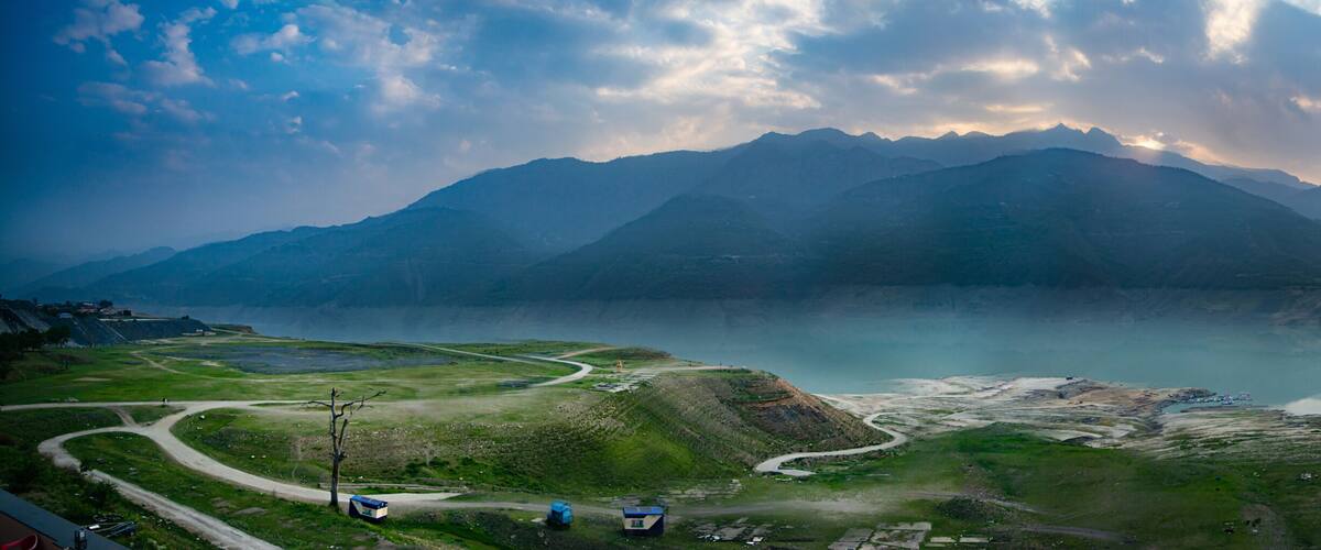 A mountainous landscape with a lake and winding roads.