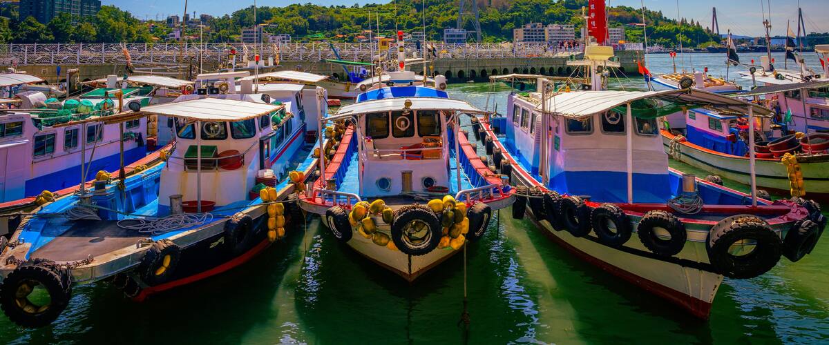 Fishing trawlers moored at Hamel Lighthouse harbor under the cable cars in Yeosu City, South Korea