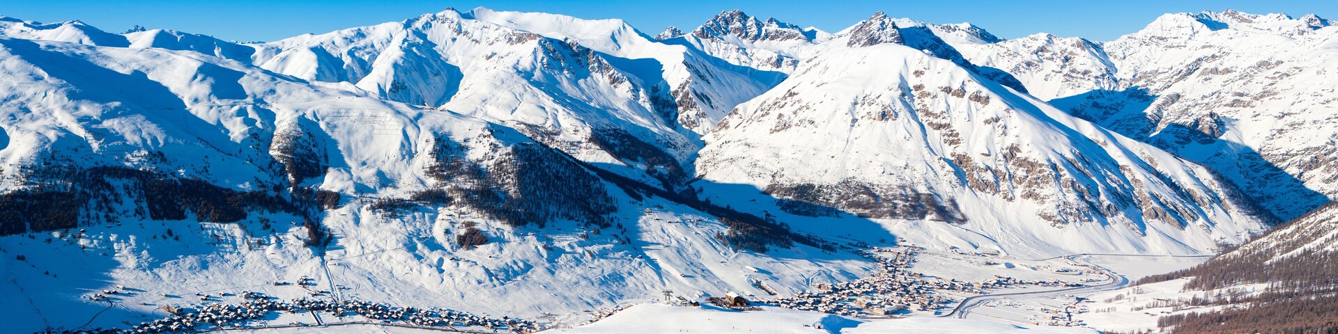 A snow-covered mountain range with a ski resort town at the base.