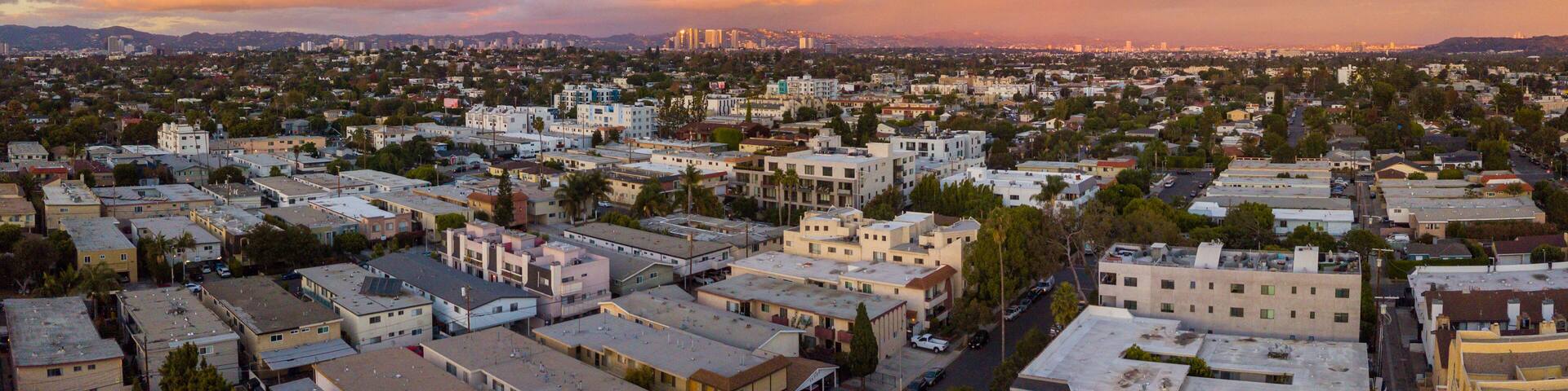 Aerial view of the Mar Vista neighborhood with the city of Los Angeles and the Santa Monica mountains in the background. Take during sunset with a drone.