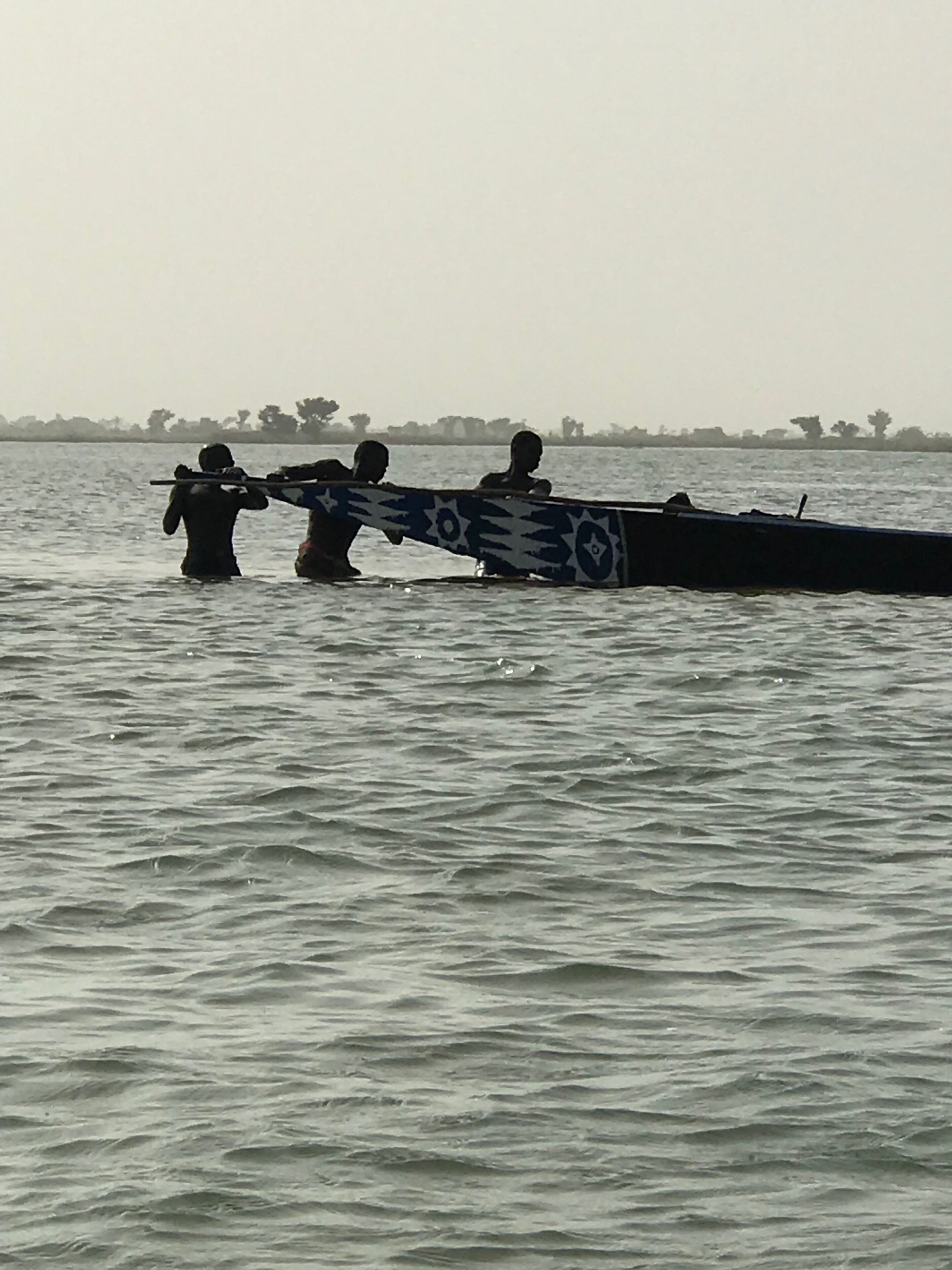 These workers, carrying sand, are trying to disengage their pirogue stuck in the shoals of Niger River.