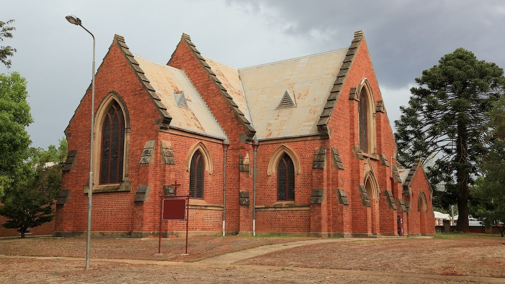 A red brick church with pointed arches and a steeply pitched roof.