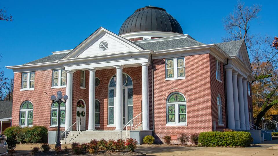 A red brick building with a large dome and columns.
