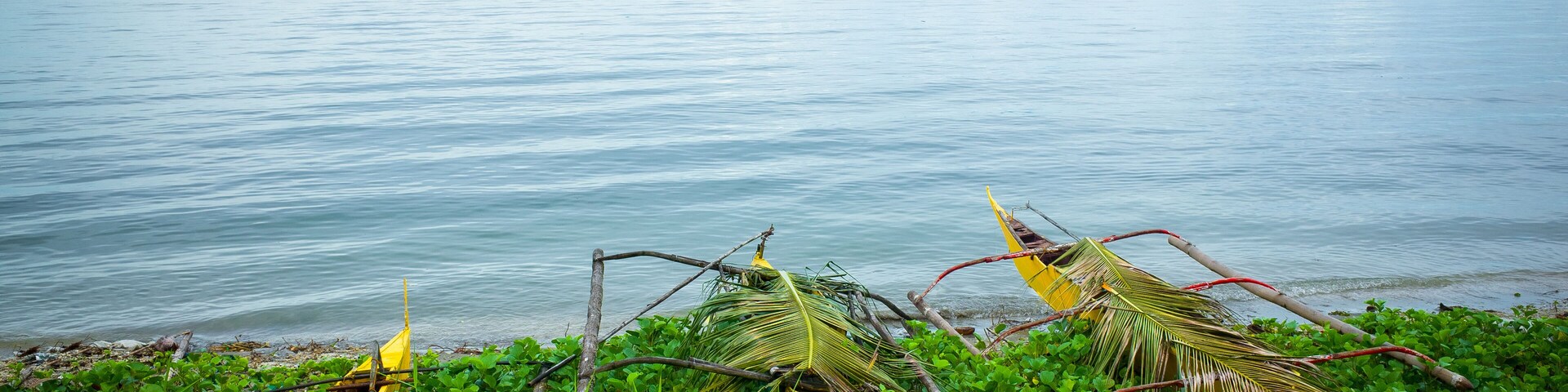 Yellow Wooden Fishing Boats Beached by a Glassy Philippine Sea