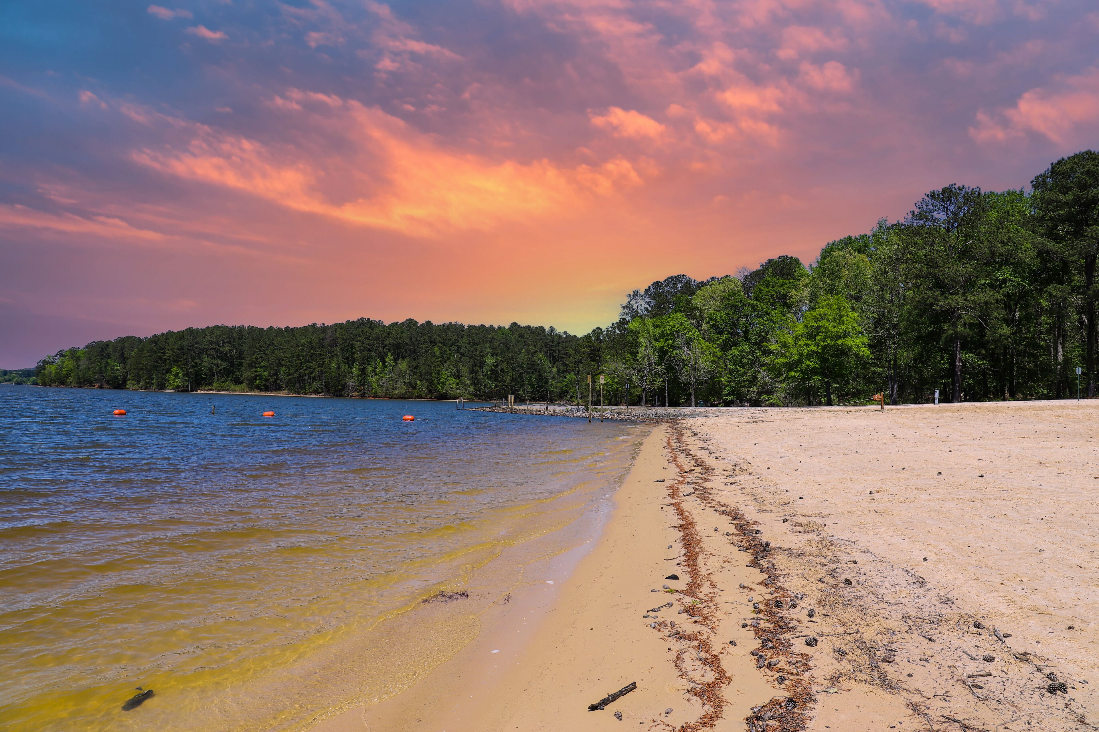 a gorgeous sandy beach on the banks of the rippling lake at sunset with powerful clouds at Dallas Landing Park in Acworth Georgia USA