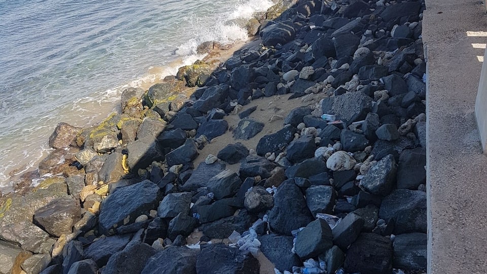 A rocky beach with waves crashing onto the shore.