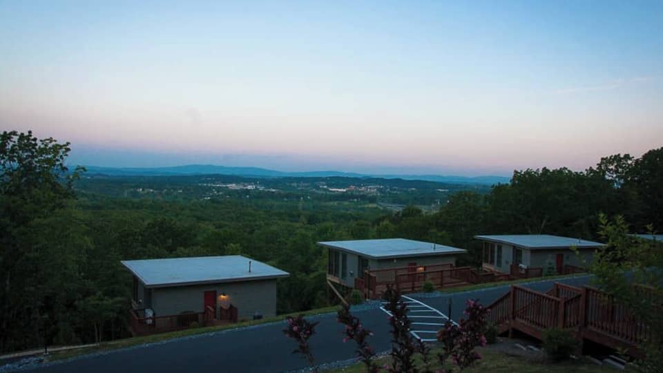 A campground with cabins and a view of the surrounding forest and mountains.