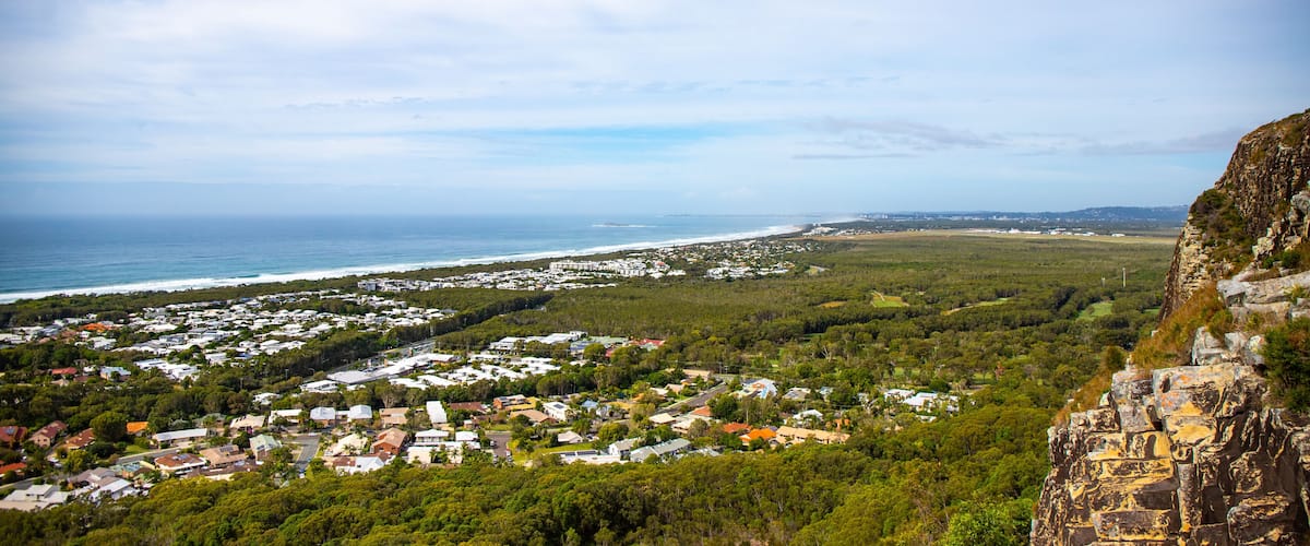 A coastal town with houses, a beach, and a cliff.