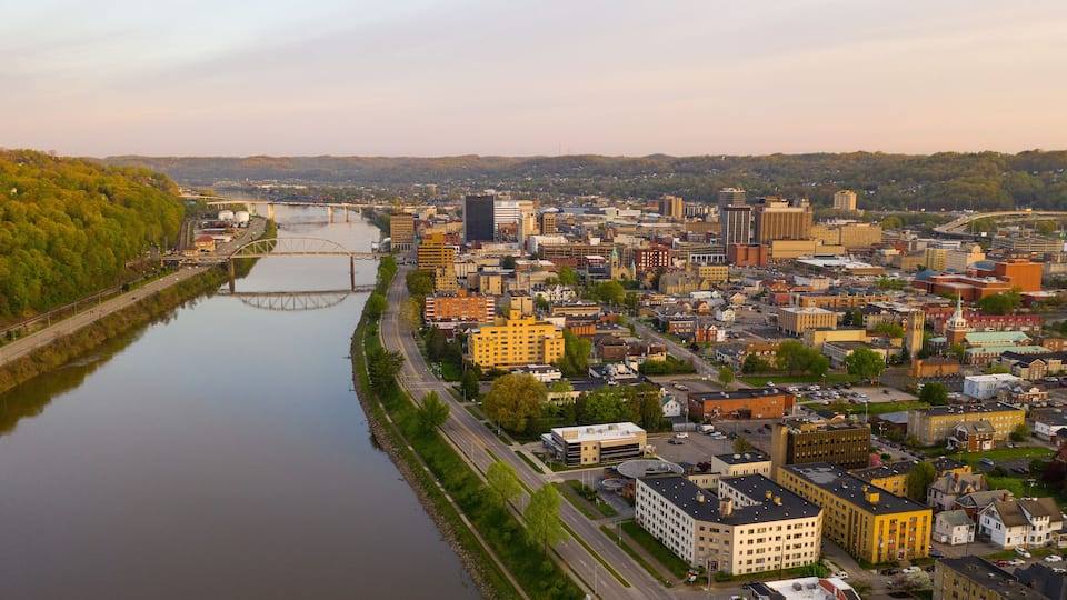 A river flowing through a city with a bridge, surrounded by buildings and greenery.