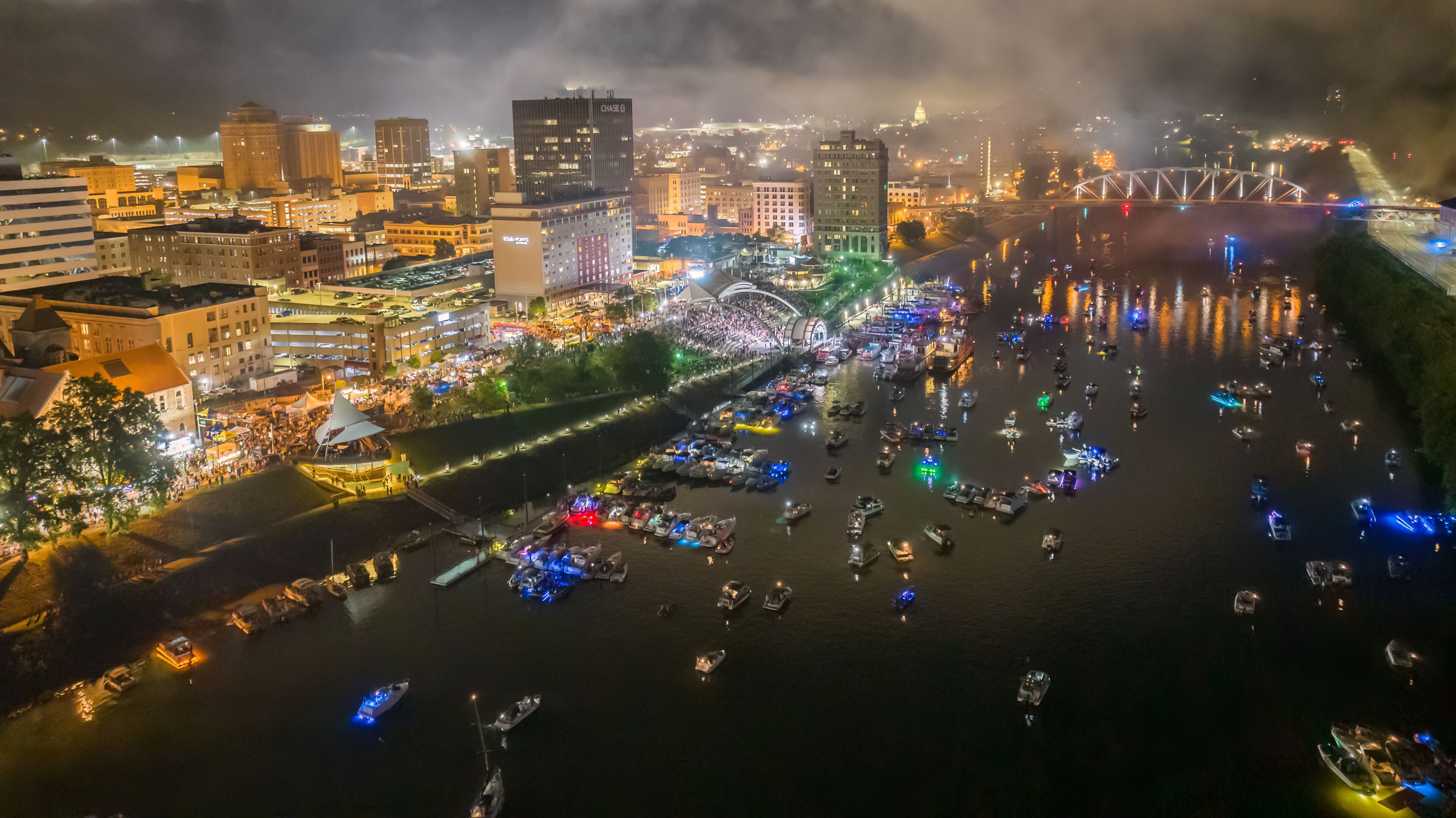 A river with boats and a cityscape with illuminated buildings at night.