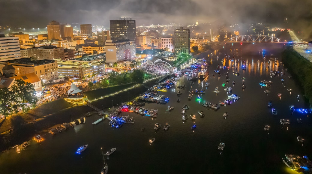 A river with boats and a cityscape with illuminated buildings at night.