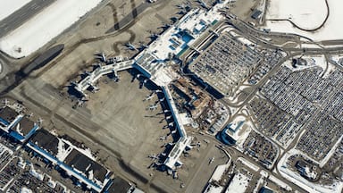 Un aeropuerto con múltiples pistas, aviones estacionados y amplios edificios terminales.