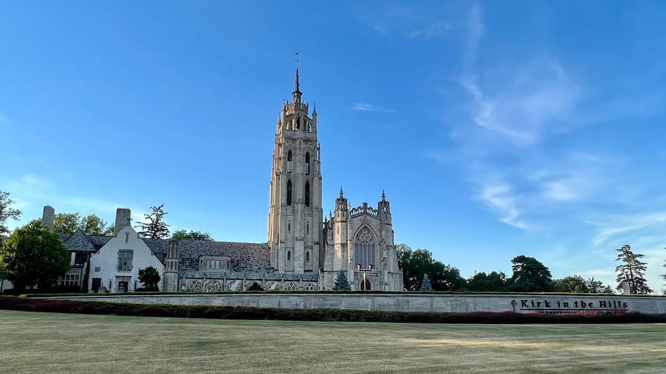 A large cathedral with a tall spire and a sign reading "Kirk in the Hills".