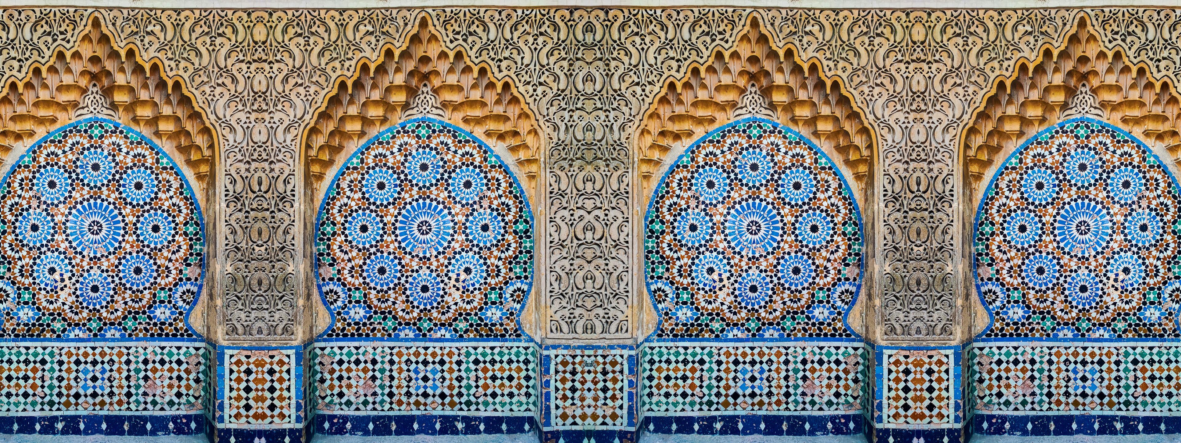 A detailed architectural facade with ornate arches and intricate tile work.