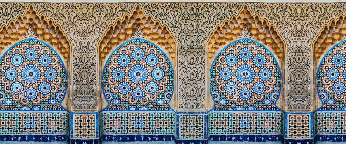 A detailed architectural facade with ornate arches and intricate tile work.