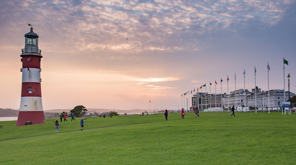 A lighthouse, a grassy field, and a row of flags.