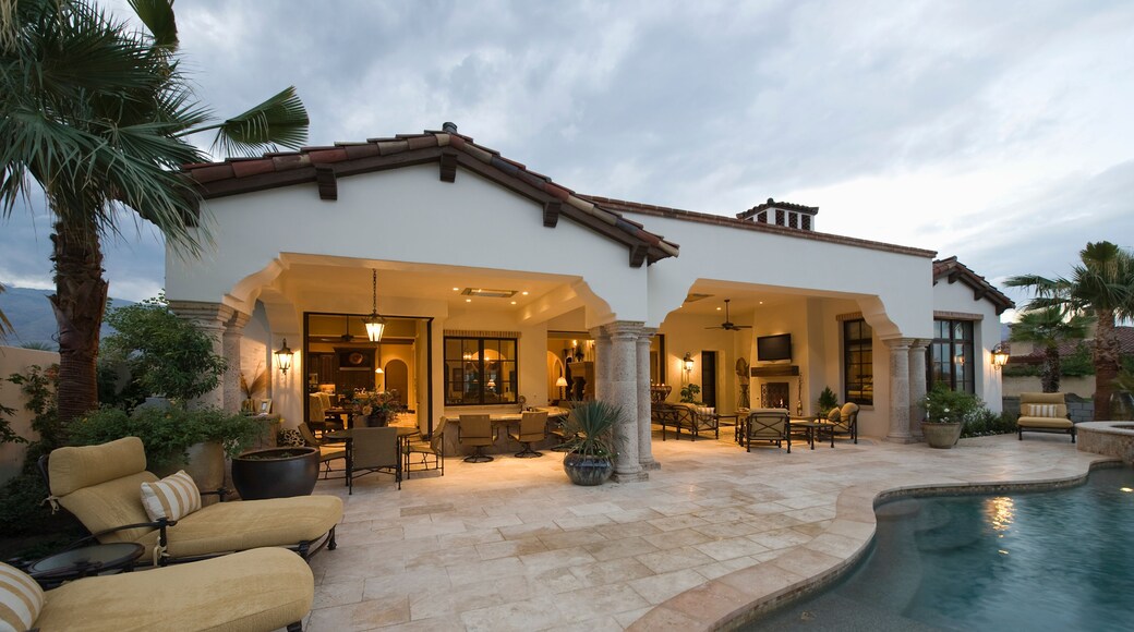 View of sunloungers by the pool against modern home