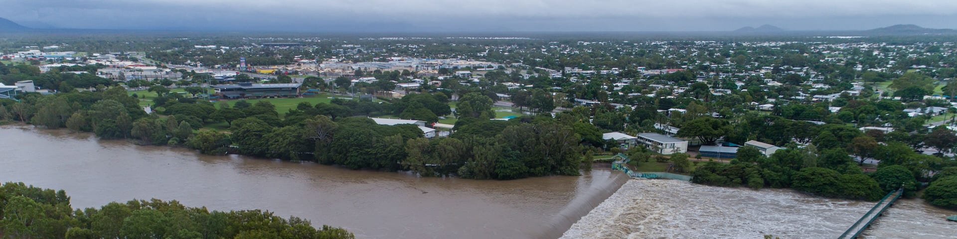 A river flooding a town, a bridge, and a building with a sign 'Riverview Tavern.'