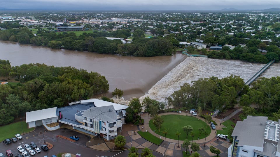 A river flooding a town, a bridge, and a building with a sign 'Riverview Tavern.'