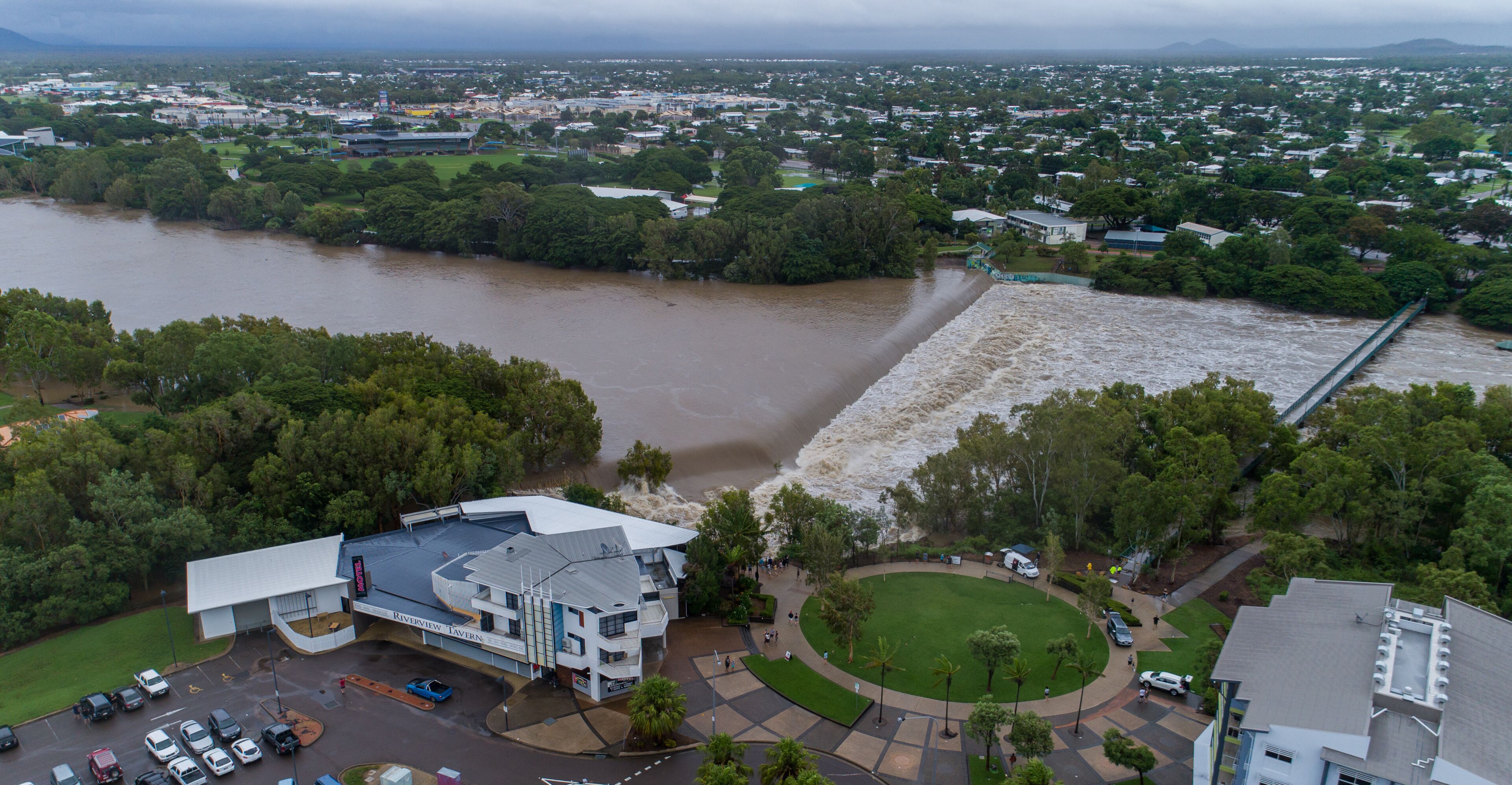 A river flooding a town, a bridge, and a building with a sign 'Riverview Tavern.'