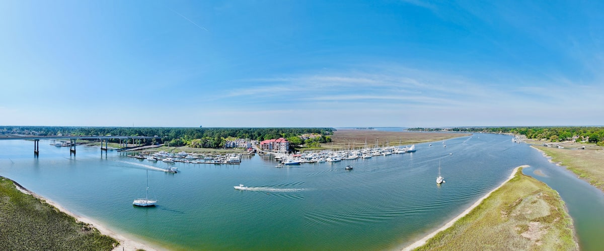 A marina with boats, a bridge, and a riverbank.