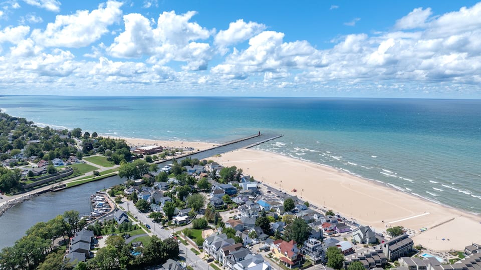 A coastal town with a beach, a pier, and a river.