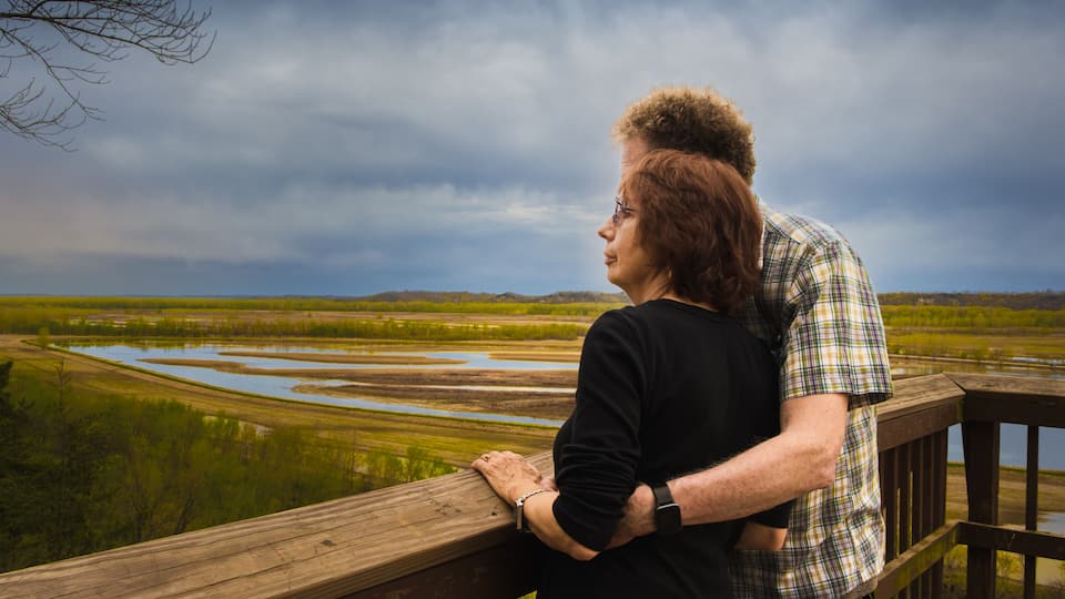 Senior couple enjoying view of Missouri River floodplain on spring evening from wooden observation deck