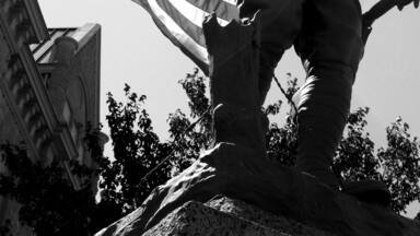 The Doughboy Viquesney WWII World War 2 Monument in Black and White with American Flag in Background in Polk County Bolivar Missouri MO