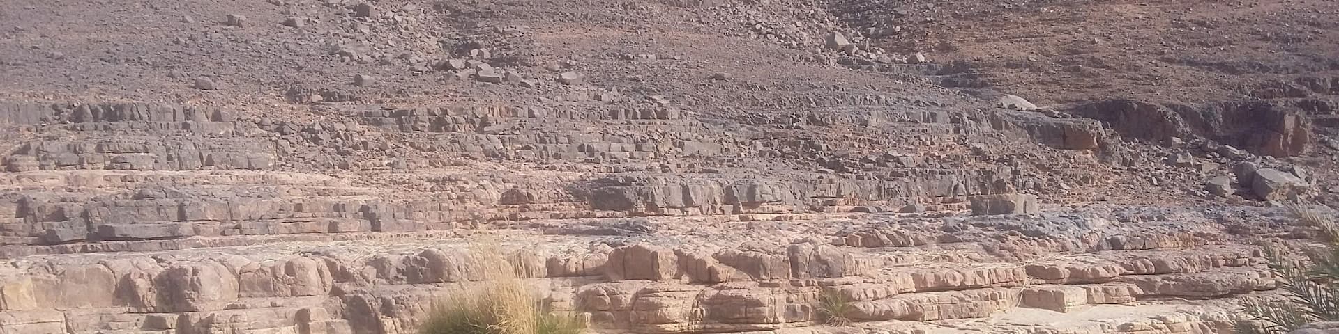 A rocky landscape with a small body of water reflecting the surrounding cliffs.