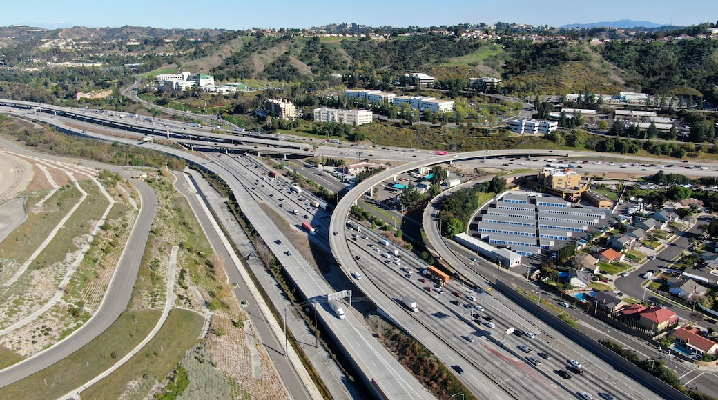 Aerial view of highway with traffic surrounded by houses in Diamond Bar City. Intersection city transport road with vehicle movement. Eastern Los Angeles, California, USA.