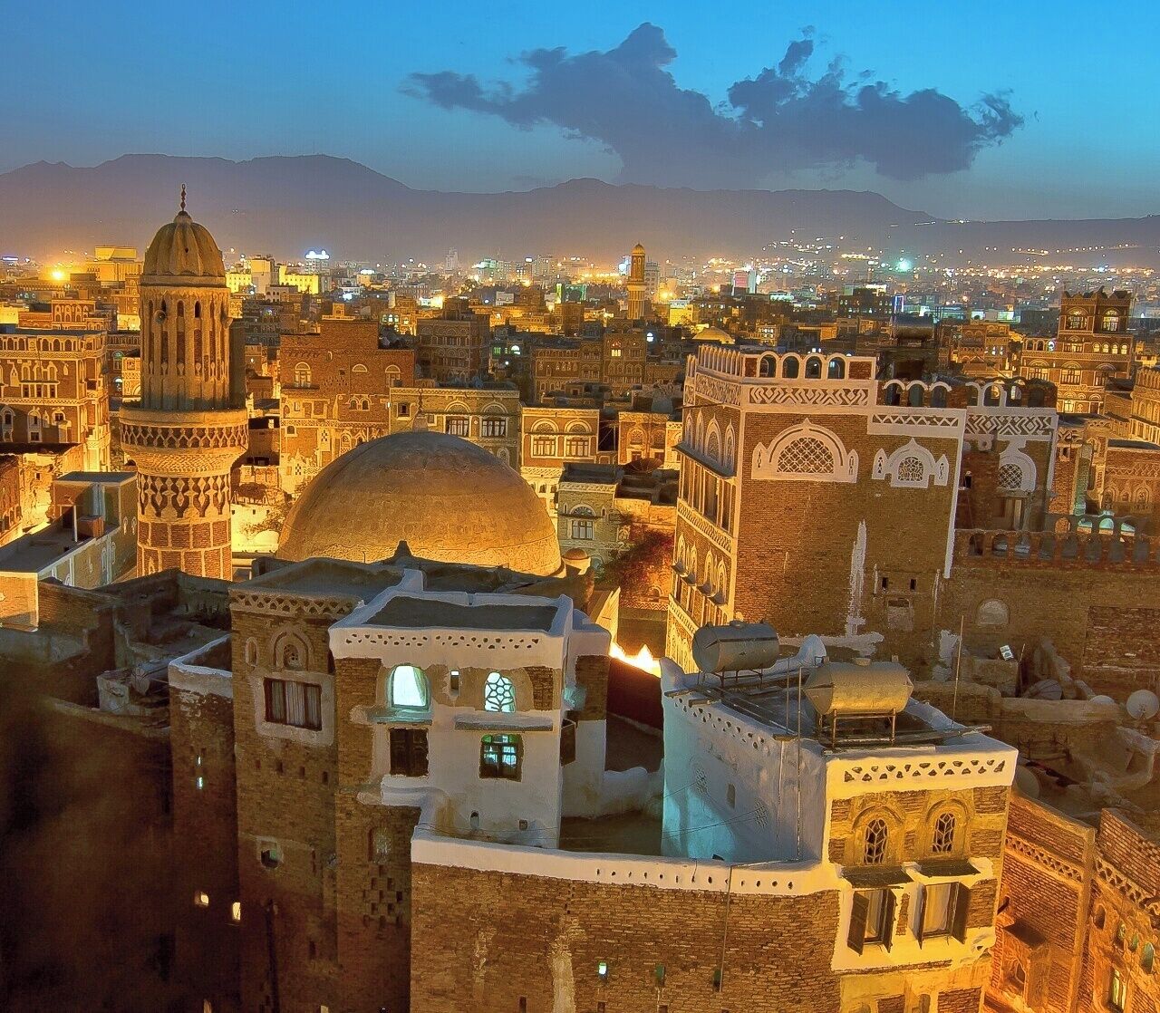 April 2008
 
Sana'a old city, Yemen 

The sundawn view from rooftop of Taj Talha hotel in Sana'a old city to the west with Talha mosque minaret and dome. The city gets the illuminated from within its windows and streetlights and you hear the muezzin's calls for the prayer from all around you... It is a One thousand and one nights stories kind of experience... 