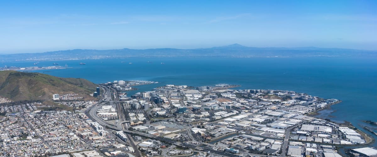 An aerial view of San Francisco with the Golden Gate Bridge, hills, and the ocean.