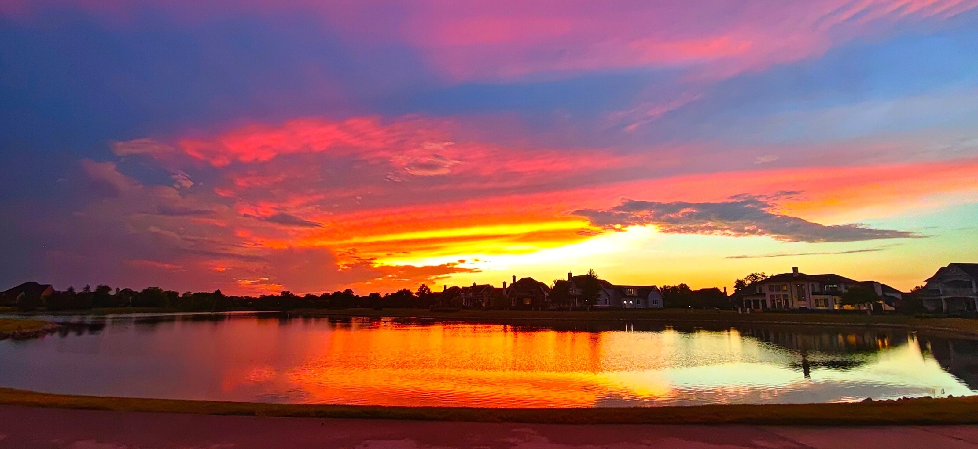 Vibrant Pink‑Purple Sunset over Lakeside Luxury Homes in Carmel, Indiana
