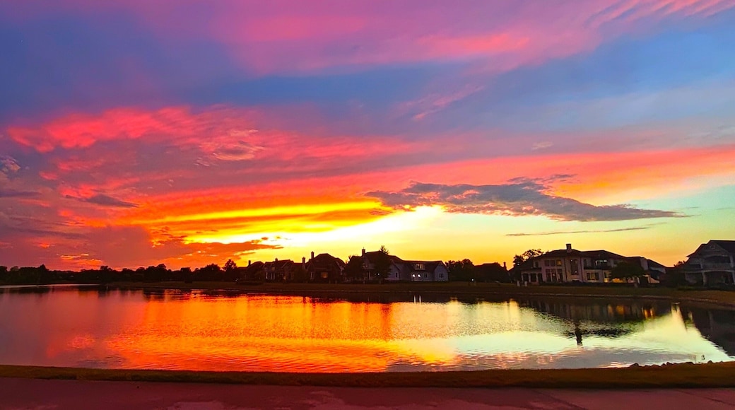 Vibrant Pink‑Purple Sunset over Lakeside Luxury Homes in Carmel, Indiana
