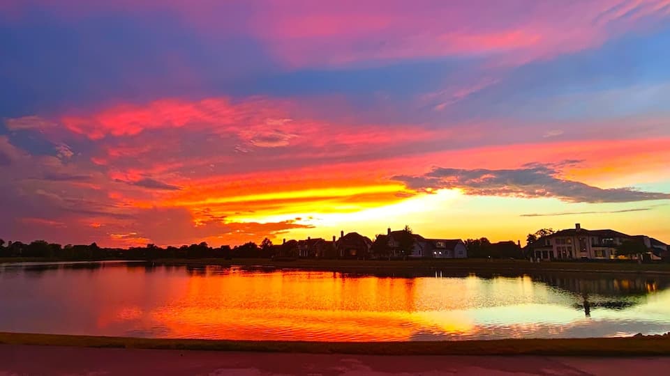 Vibrant Pink‑Purple Sunset over Lakeside Luxury Homes in Carmel, Indiana